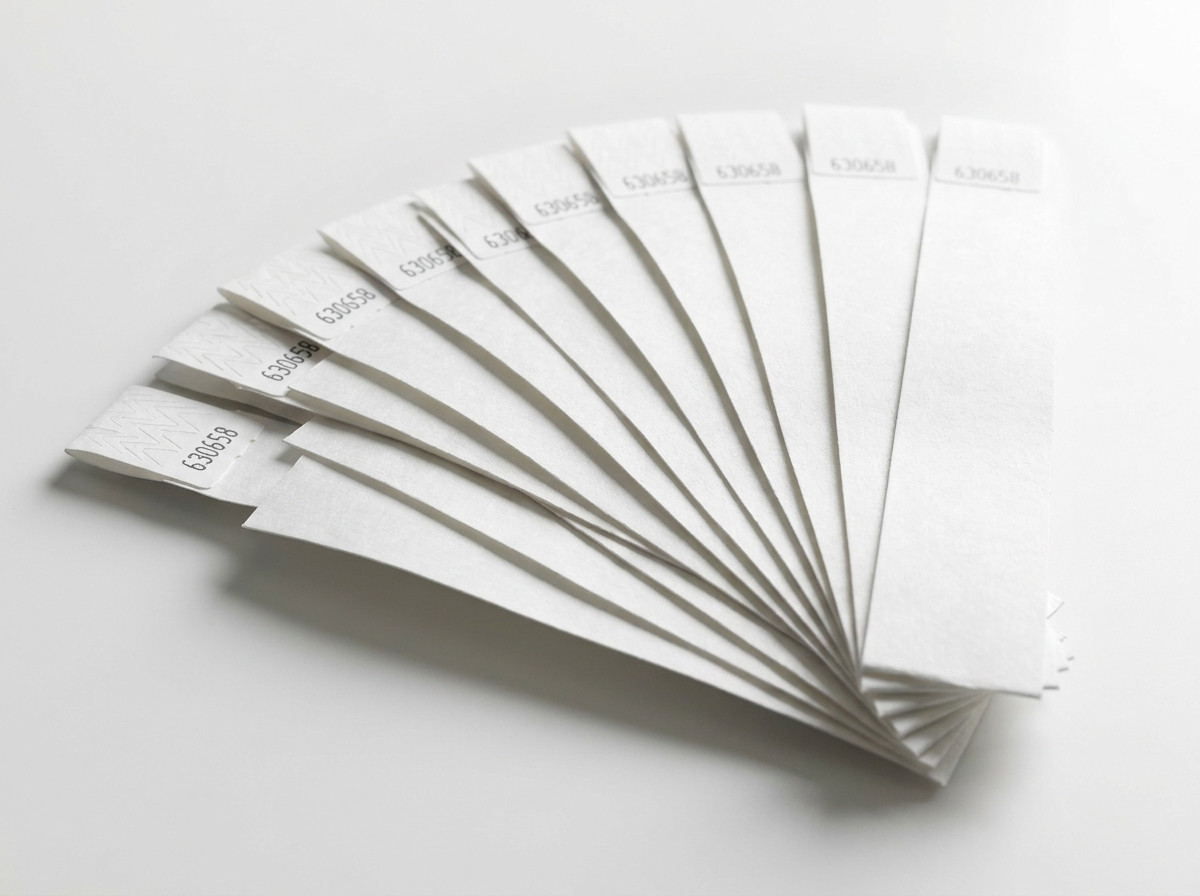 Set of white rigid plastic wristbands arranged in a fan, ready to distribute